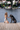 Woman kneeling on dog in front of black Cane Corso dog