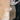 A light blue slow feeder bowl filled with kibble and topped with supplements, held by a person next to a golden retriever puppy looking up at it.